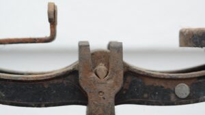 Close up of cast iron vintage scale, showing a forked post holding a balanced beam.